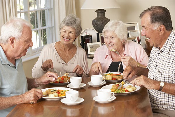 Group-Of-Senior-Couples-Enjoying-Meal-Together