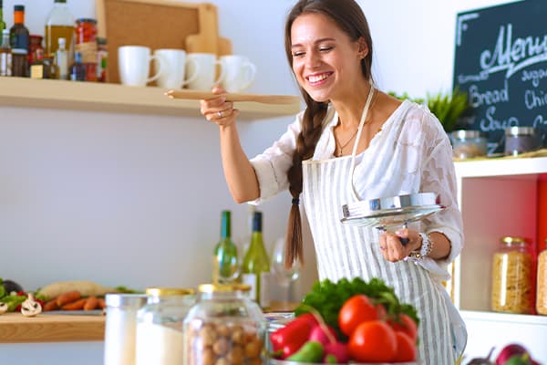 Cooking-woman-in-kitchen-with-wooden-spoon
